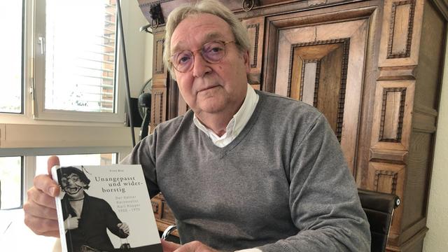 Gerhard Küpper hält eine Biographie seines Vaters mit dem Titel "Unangepasst und widerborstig" in der Hand