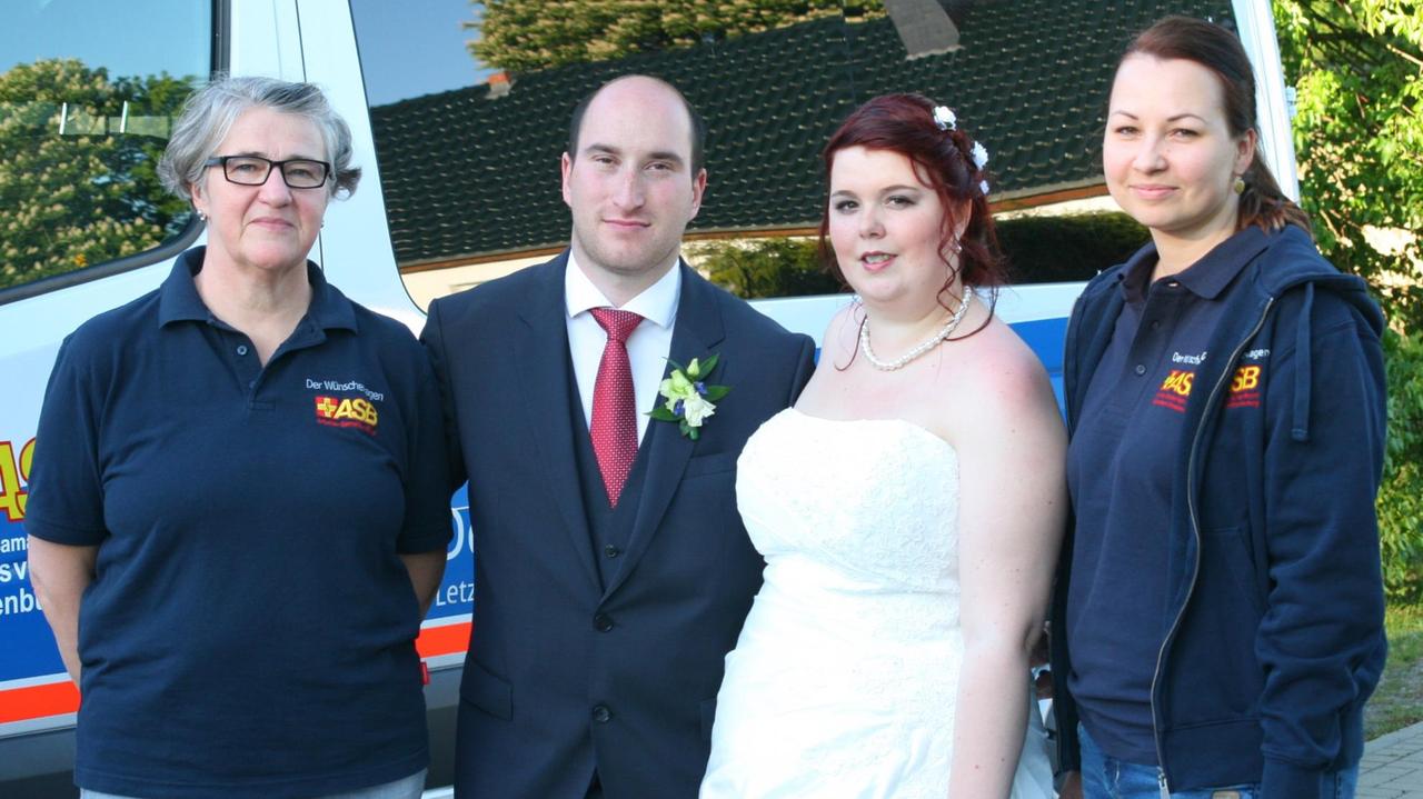 Das Hochzeitspaar mit dem Wünschewagenteam Das Hochzeitspaar mit dem Wünschewagenteam