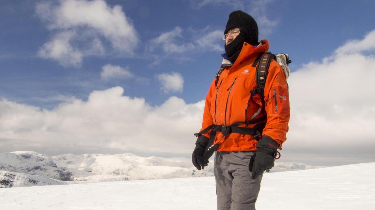 Im Winter 2013 im Lake District, Vereinigtes Königreich. Ein Mann trägt eine Sturmhaube während eines Winterspazierganges im Schnee in den Bergen. Im Winter 2013 im Lake District, Vereinigtes Königreich. Ein Mann trägt eine Sturmhaube während eines Winterspazierganges im Schnee in den Bergen.