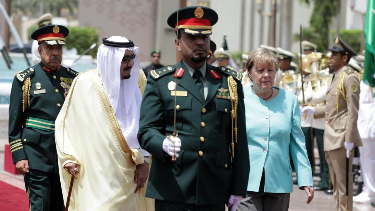 Bundeskanzlerin Angela Merkel (M, CDU) wird am 30.04.2017 in Dschidda (Saudi-Arabien) vom König des Königreichs Saudi-Arabiens, Hüter der Heiligen Stätten, Salman bin Abdelaziz Al Saud (2.v.l) mit militärischen Ehren begrüßt. Saudische Soldaten salutieren. Bundeskanzlerin Angela Merkel (M, CDU) wird am 30.04.2017 in Dschidda (Saudi-Arabien) vom König des Königreichs Saudi-Arabiens, Hüter der Heiligen Stätten, Salman bin Abdelaziz Al Saud (2.v.l) mit militärischen Ehren begrüßt. Saudische Soldaten salutieren.