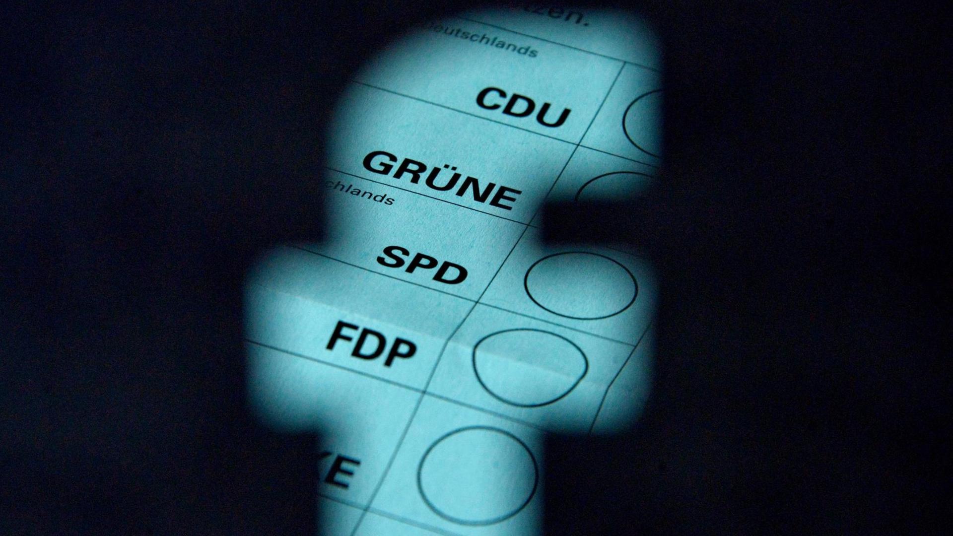 Unter einem ausgeschnittenen Facebook-Logo liegt ein Wahlschein Unter einem ausgeschnittenen Facebook-Logo liegt ein Wahlschein