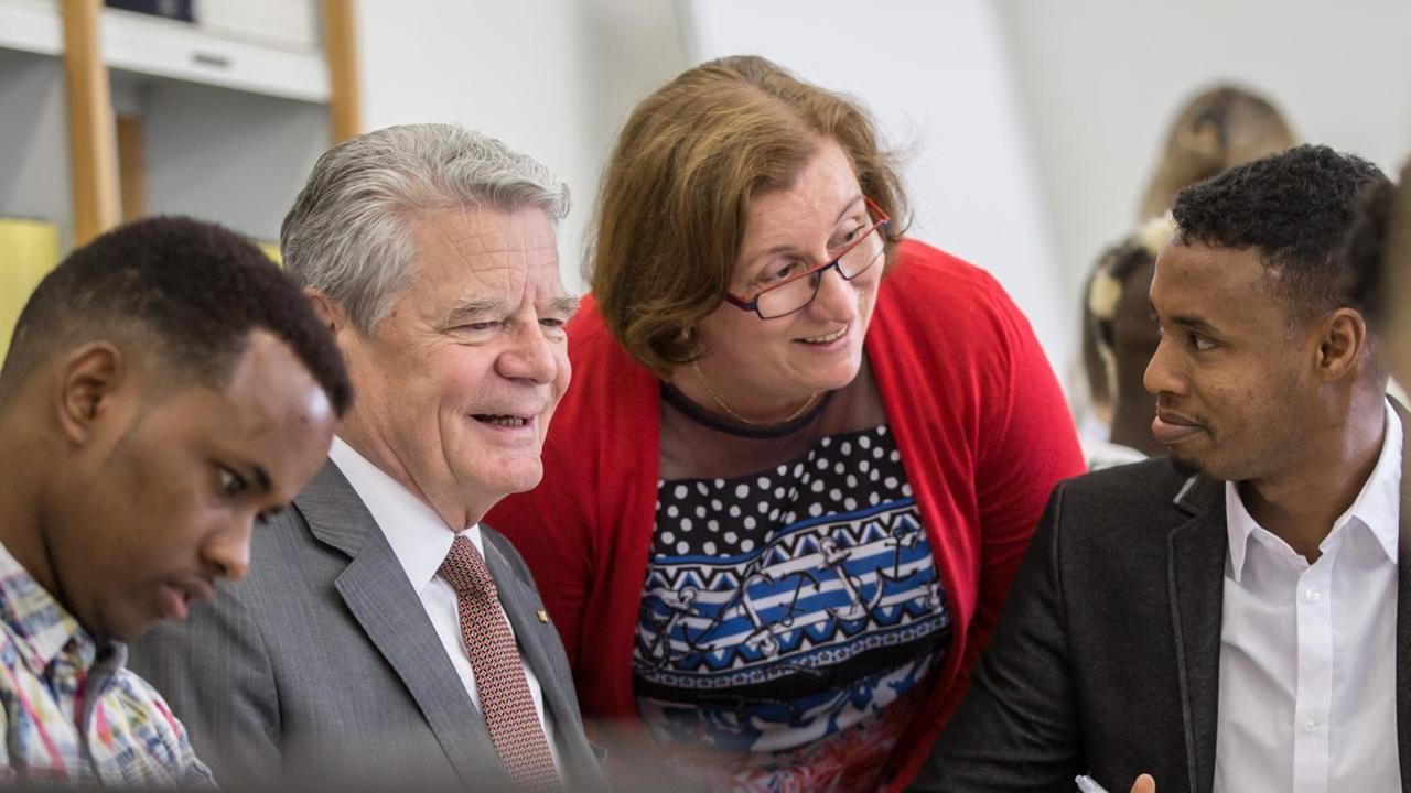 Bundespräsident Joachim Gauck(2.v.l.) und Schulleiterin Annette Greilich (M) sprechen am 17.06.2015 in Gießen (Hessen) an der beruflichen Friedrich-Feld-Schule mit jugendlichen Flüchtlingen, die hier unter Anleitung von Berufsfachschülern und Lehrern im Rahmen der Initiative "DaZuLERNEN" Deutschunterricht erhalten. Bundespräsident Joachim Gauck(2.v.l.) und Schulleiterin Annette Greilich (M) sprechen am 17.06.2015 in Gießen (Hessen) an der beruflichen Friedrich-Feld-Schule mit jugendlichen Flüchtlingen, die hier unter Anleitung von Berufsfachschülern und Lehrern im Rahmen der Initiative "DaZuLERNEN" Deutschunterricht erhalten.
