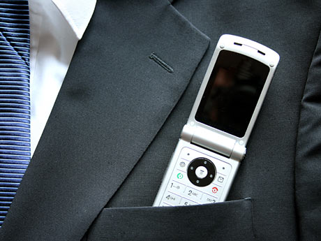 Ein Mobiltelefon steckt in einer Anzugjacke Ein Mobiltelefon steckt in einer Anzugjacke
