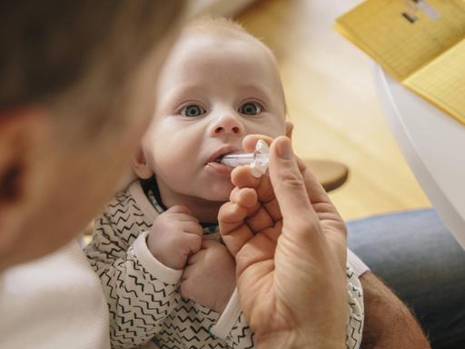 Ein drei Monate altes Baby erhält eine orale Impfung.
