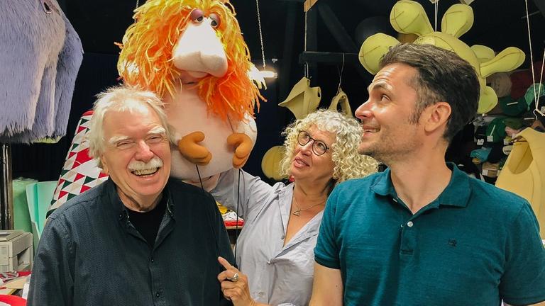 Das Ehepaar Röders und Moderator Tim Wiese posieren in der Puppenwerkstatt mit einer selbstgebauten Puppe. Das Ehepaar Röders und Moderator Tim Wiese posieren in der Puppenwerkstatt mit einer selbstgebauten Puppe.