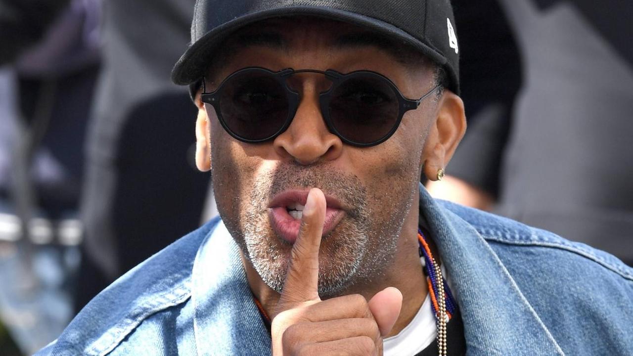 Spike Lee guckt in die Kamera und legt seinen Zeigefinger auf den Mund. Spike Lee guckt in die Kamera und legt seinen Zeigefinger auf den Mund.