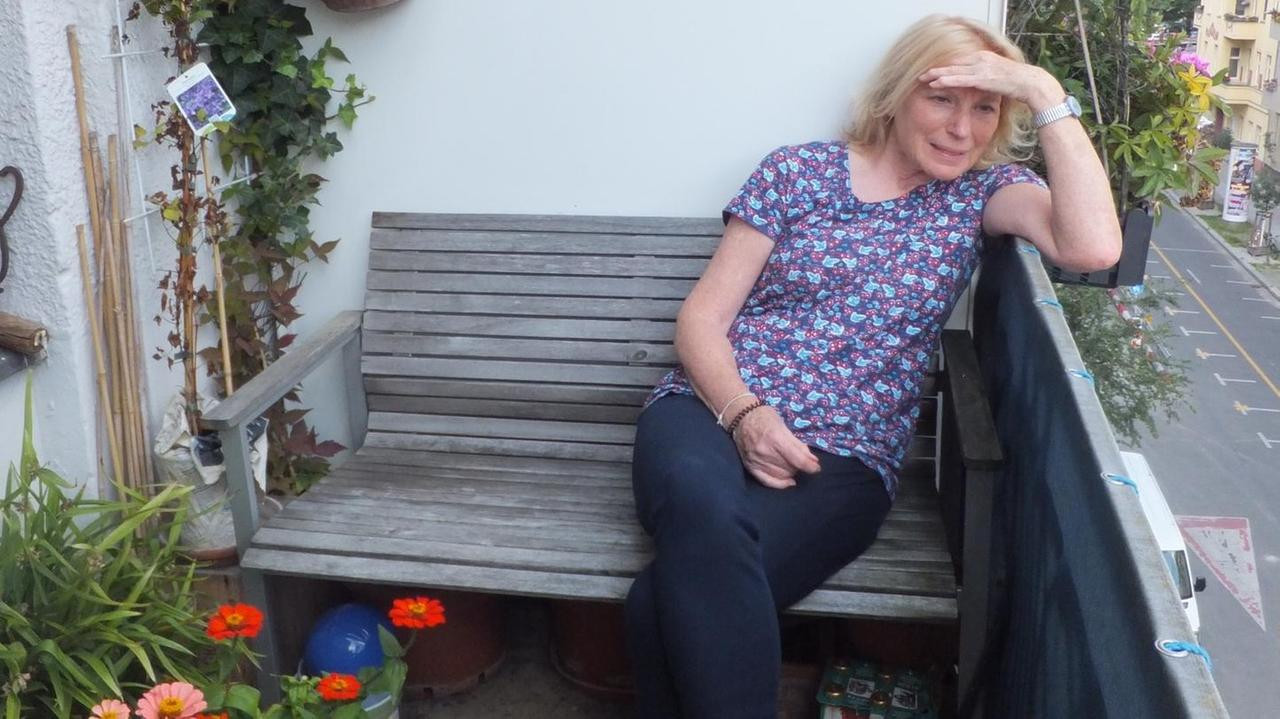 Maren Kroymann sitzt auf ihrem begrünten Balkon und hält sich die Hand als Sonnenschutz vor der Stirn. Maren Kroymann sitzt auf ihrem begrünten Balkon und hält sich die Hand als Sonnenschutz vor der Stirn.