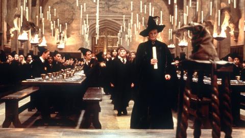 Die Professorin Minerva McGonagall (Maggie Smith) führt in einer Szene des Kinofilms "Harry Potter und der Stein der Weisen" die neuen Zauberlehrlinge mit einer Kerze in der Hand durch einen riesigen Saal der Hogwarts-Schule für Zauberkunst.