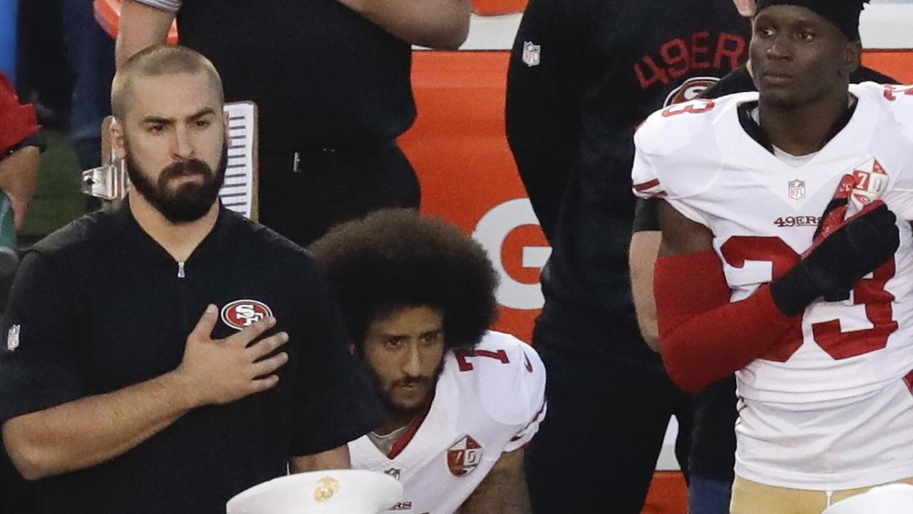 Der Quarterback der San Francisco 49ers, Colin Kaepernick, kniet während der Nationalhymne. Der Quarterback der San Francisco 49ers, Colin Kaepernick, kniet während der Nationalhymne.