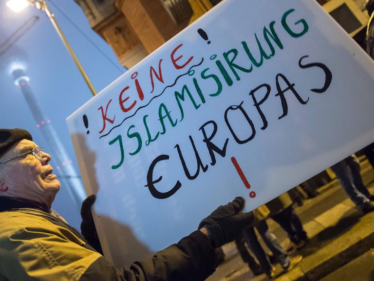 Ein Anhänger der Pegida-Bewegung demonstriert gegen die angebliche Islamisierung Europas. Er hält ein Schild mit der Aufschrift: "Keine Islamisirung Europas".