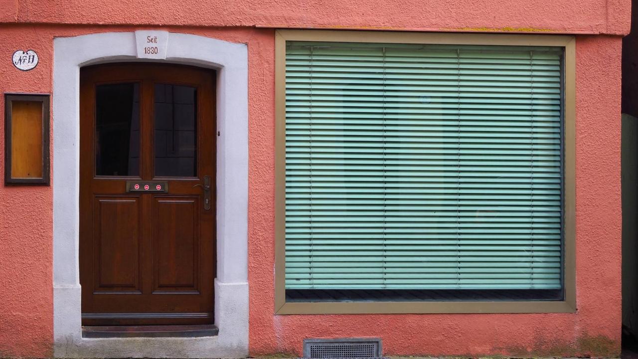 Ein geschlossenes Geschäft mit heruntergelassenen Rolläden in der Altstadt von Dinkelsbühl Ein geschlossenes Geschäft mit heruntergelassenen Rolläden in der Altstadt von Dinkelsbühl