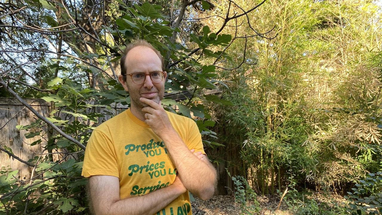 Ein Mann mit lichtem Haar und gelbem T-Shirt steht in einer grünen Landschaft. Ein Mann mit lichtem Haar und gelbem T-Shirt steht in einer grünen Landschaft.