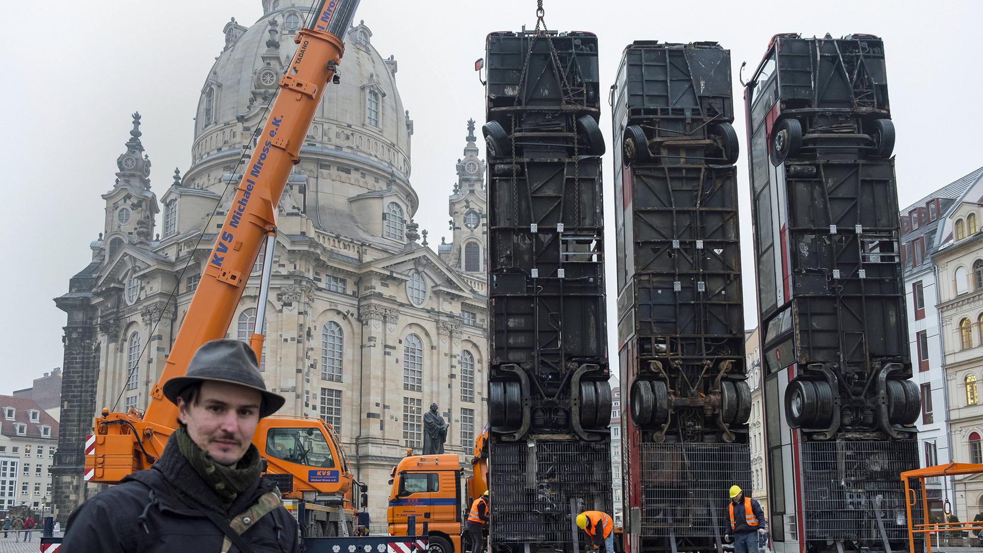 Im Dresdner Stadtzentrum erinnert eine Kunstinstallation an den Krieg in Syrien - eine Woche vor dem Jahrestag der Zerstörung Dresdens am 13. Februar 1945. Auf dem zentralen Neumarkt vor der Frauenkirche hat der Deutsch-Syrier Manaf Halbouni am Montag drei Busse hochkant aufgestellt. Die Installation mit dem Titel Monument erinnert an ein Bild aus Aleppo, das 2015 um die Welt ging. Im Dresdner Stadtzentrum erinnert eine Kunstinstallation an den Krieg in Syrien - eine Woche vor dem Jahrestag der Zerstörung Dresdens am 13. Februar 1945. Auf dem zentralen Neumarkt vor der Frauenkirche hat der Deutsch-Syrier Manaf Halbouni am Montag drei Busse hochkant aufgestellt. Die Installation mit dem Titel Monument erinnert an ein Bild aus Aleppo, das 2015 um die Welt ging.