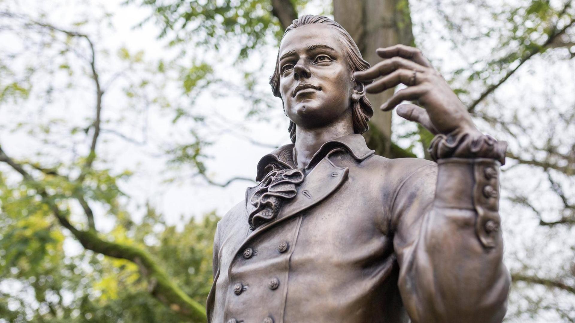 Bild der Statue von Friedrich Hölderlin unter Bäumen in Nürtingen. Bild der Statue von Friedrich Hölderlin unter Bäumen in Nürtingen.