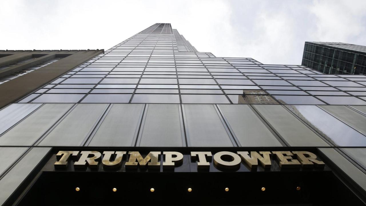 Das Bild zeigt den Schriftzug "Trump Tower". Das Gebäude ist von von unten zur Spitze aufschauend fotografiert.