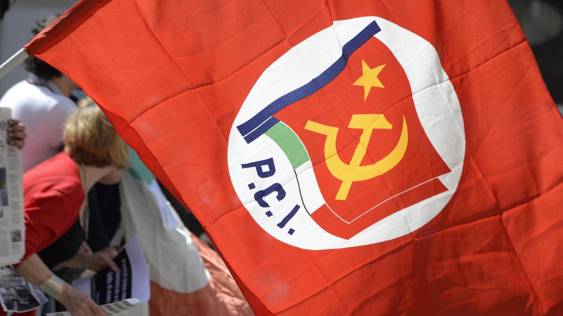 Ein Demonstrant trägt eine Flagge der Kommunistischen Partei Italiens (PCI) bei einer Kundgebung vor dem Parlament in Rom im April 2013 Ein Demonstrant trägt eine Flagge der Kommunistischen Partei Italiens (PCI) bei einer Kundgebung vor dem Parlament in Rom im April 2013
