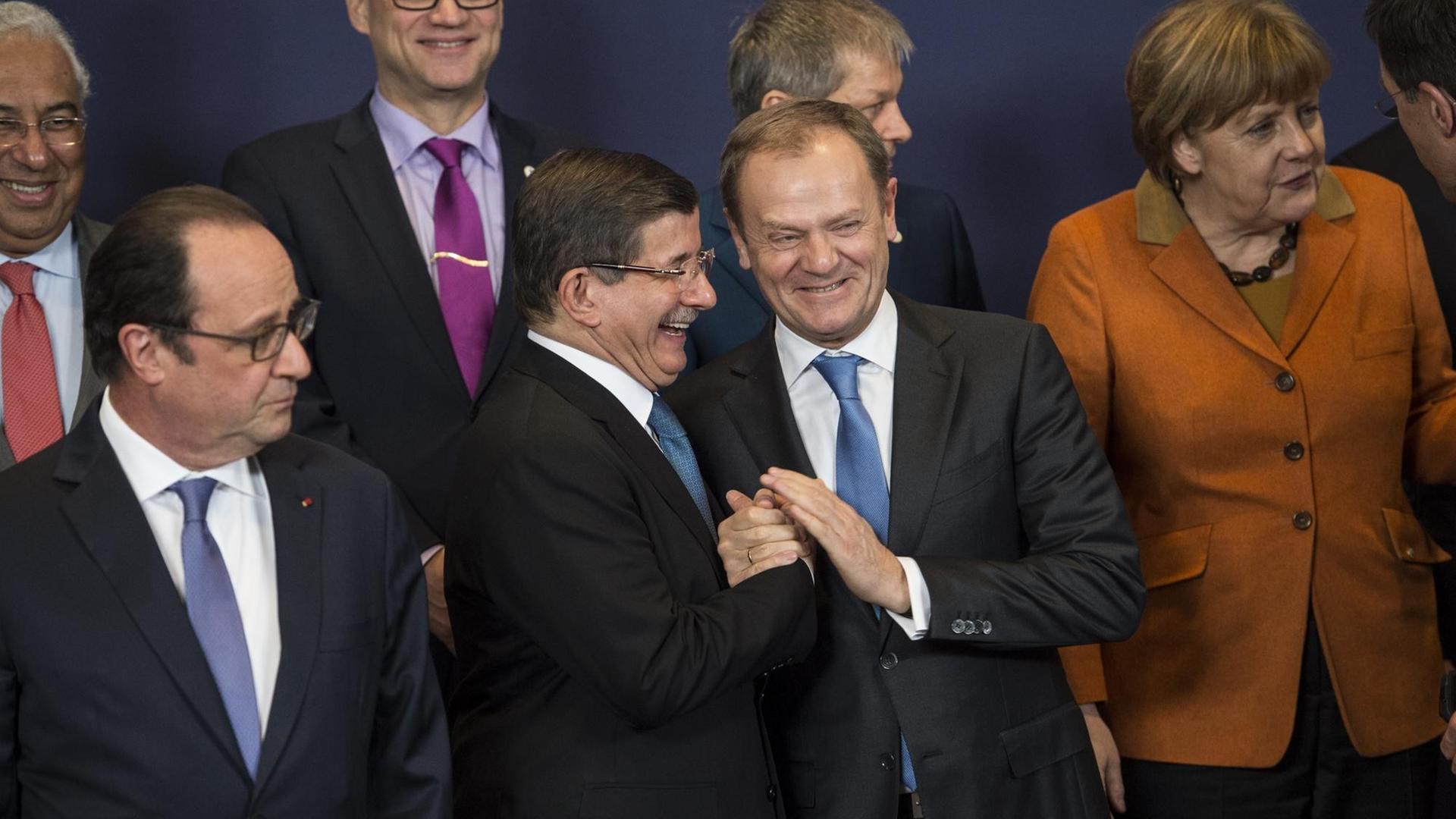 François Hollande, Ahmed Davutoglu, Donald Tusk und Angela Merkel unterhalten sich beim Aufstellen zum Gruppenfoto.