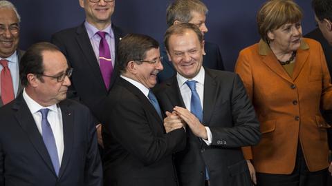 François Hollande, Ahmed Davutoglu, Donald Tusk und Angela Merkel unterhalten sich beim Aufstellen zum Gruppenfoto.
