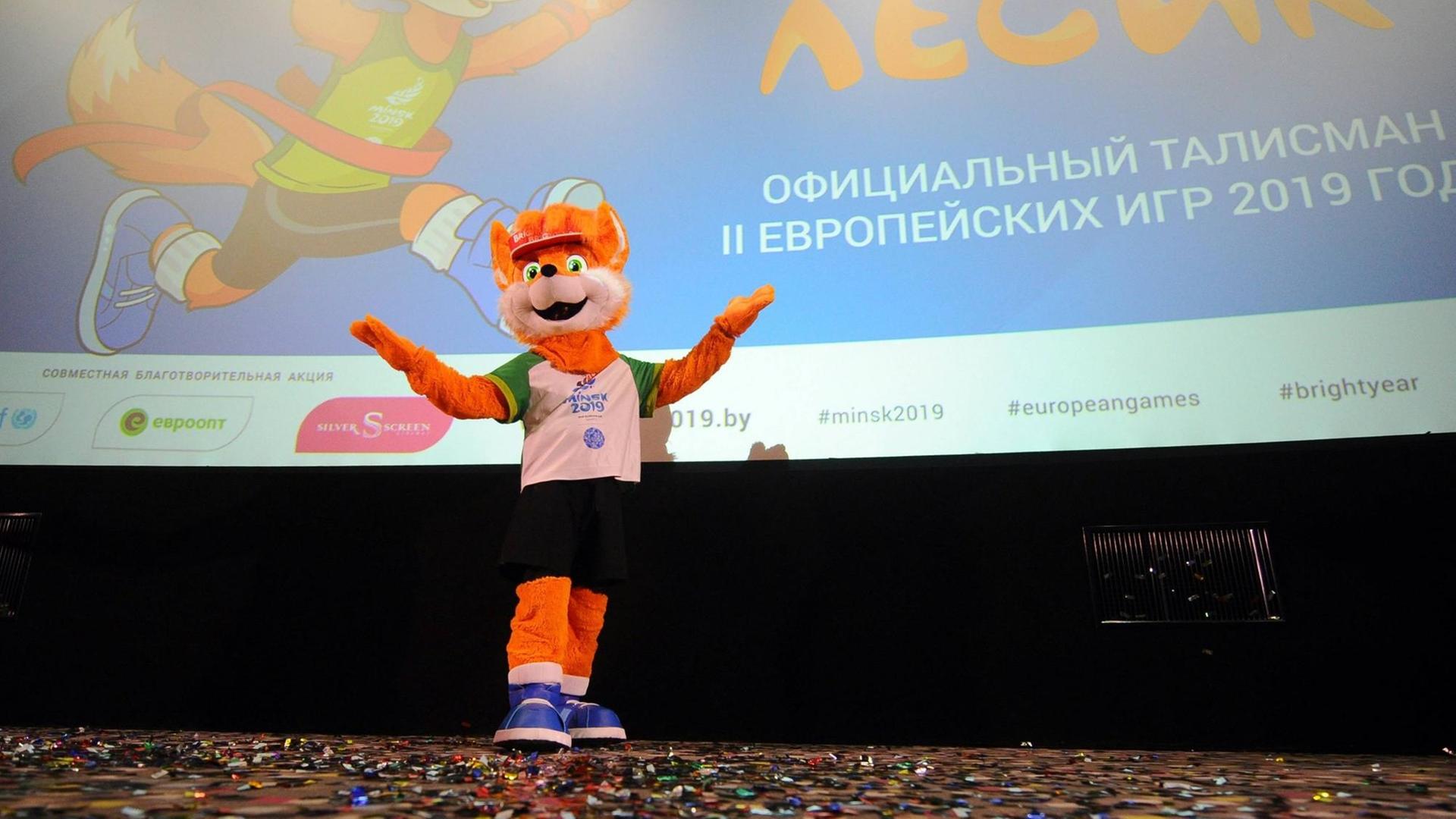 Das Maskottchen der Europaspiele in Weißrussland, ein Mensch in einem Plüschfuchs-Kostüm, vor einer Leinwand Das Maskottchen der Europaspiele in Weißrussland, ein Mensch in einem Plüschfuchs-Kostüm, vor einer Leinwand