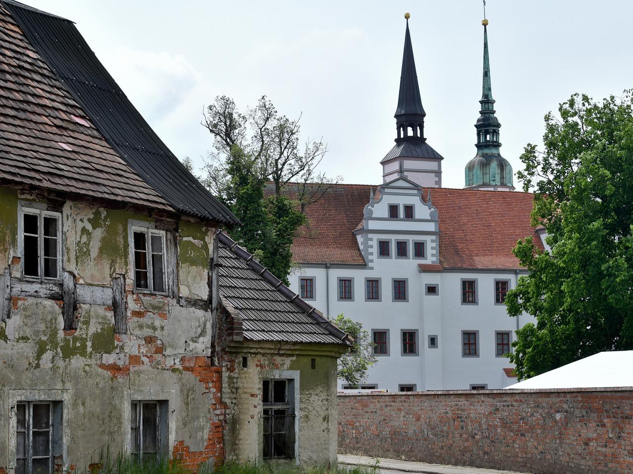 Ein völlig marodes und altes Fachwerkhaus ist neben dem schmucken Schloss Doberlug in Doberlug-Kirchhain (Brandenburg) zu sehen.