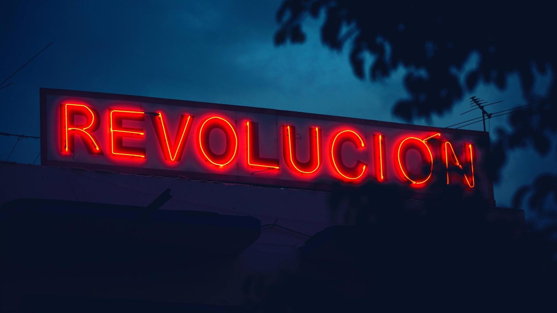Eine rote Leuchtreklame mit dem spanischen Schriftzug Revolucion im Abendlicht in Kuba. Eine rote Leuchtreklame mit dem spanischen Schriftzug Revolucion im Abendlicht in Kuba.