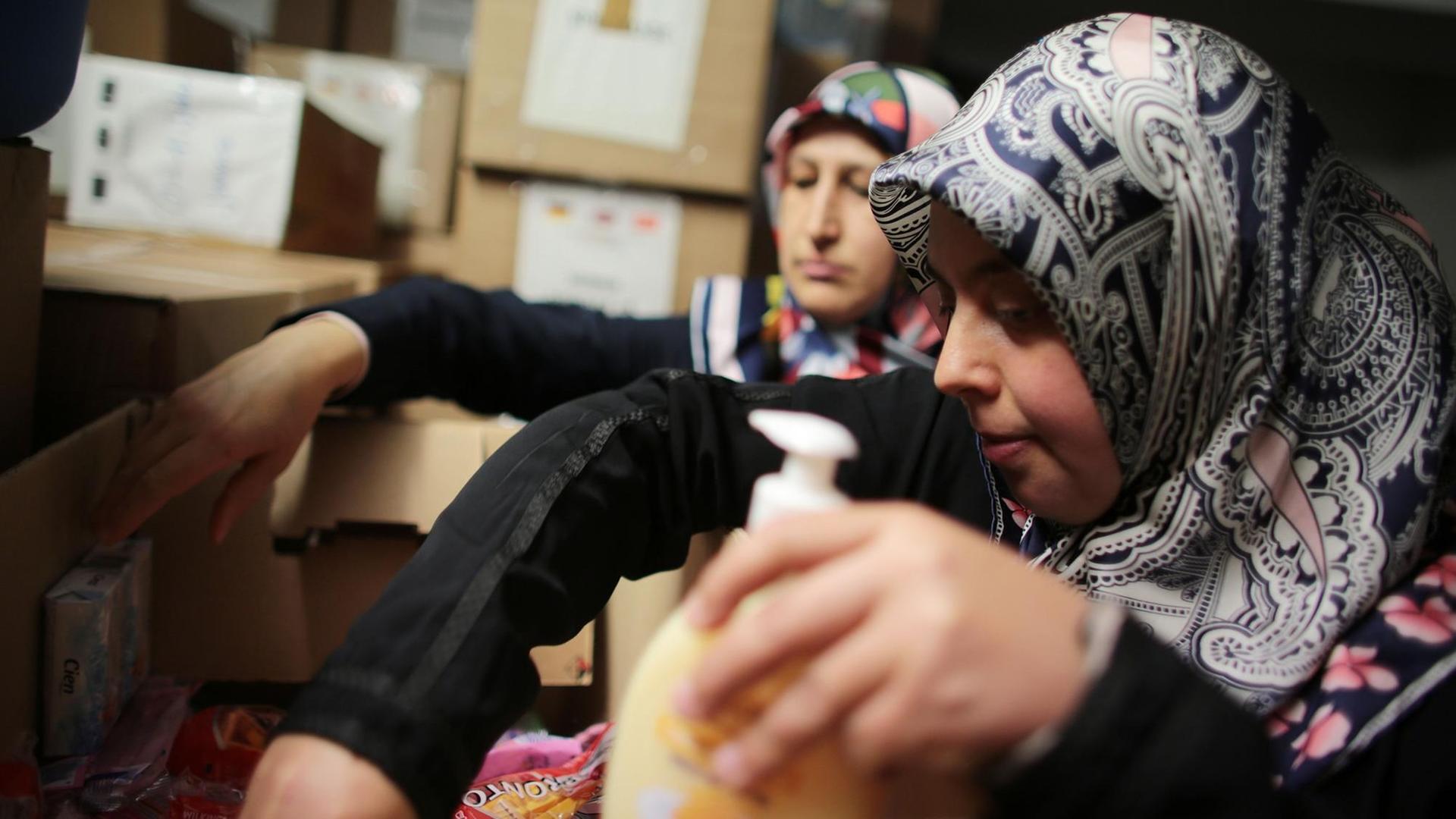 Die türkischen Frauen Sevgül Tunc (r) und Hayriye Aydin sortieren in einer Kölner Moschee Spenden für Flüchtlinge. Die türkischen Frauen Sevgül Tunc (r) und Hayriye Aydin sortieren in einer Kölner Moschee Spenden für Flüchtlinge.