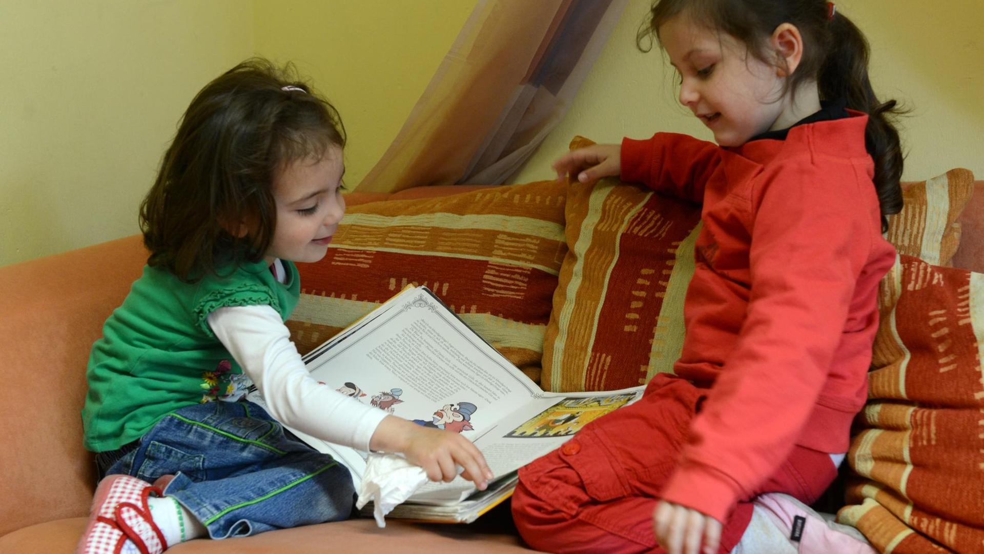 Zwei Kinder gucken in ein Buch Zwei Kinder gucken in ein Buch