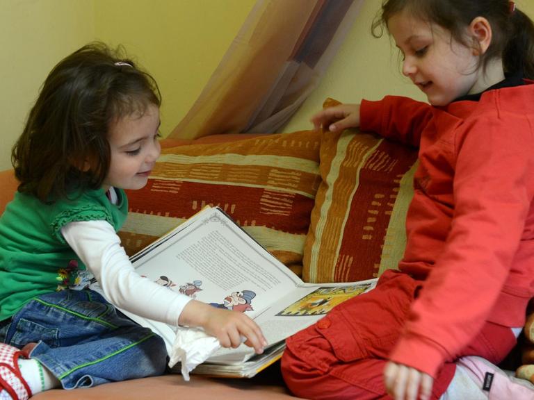 Zwei Kinder gucken in ein Buch