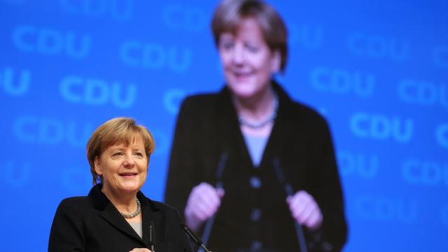 Die CDU-Bundesvorsitzende und Bundeskanzlerin Angela Merkel begrüßt am 14.12.2015 in Karlsruhe (Baden-Württemberg) beim Beginn des Bundesparteitages die Delegierten.