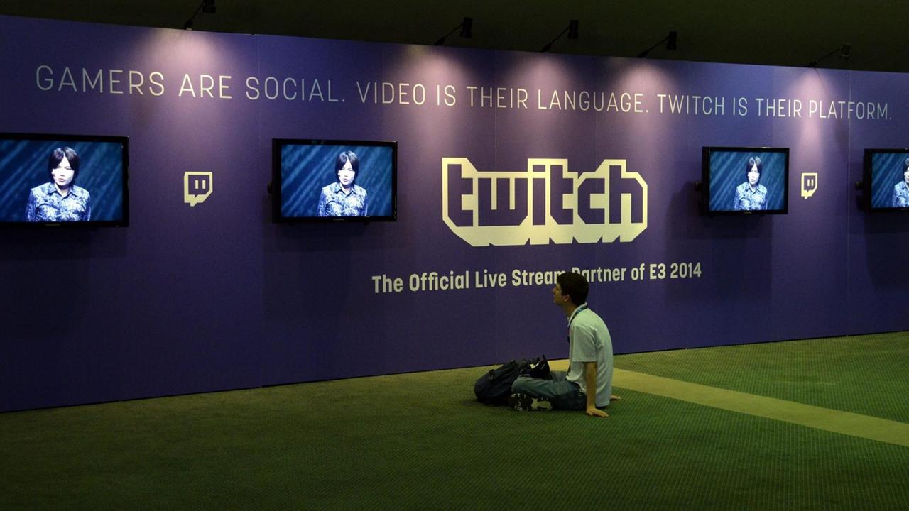 Ein junger Mann sitzt vor Bildschirmen der Streamingplatform Twitch.