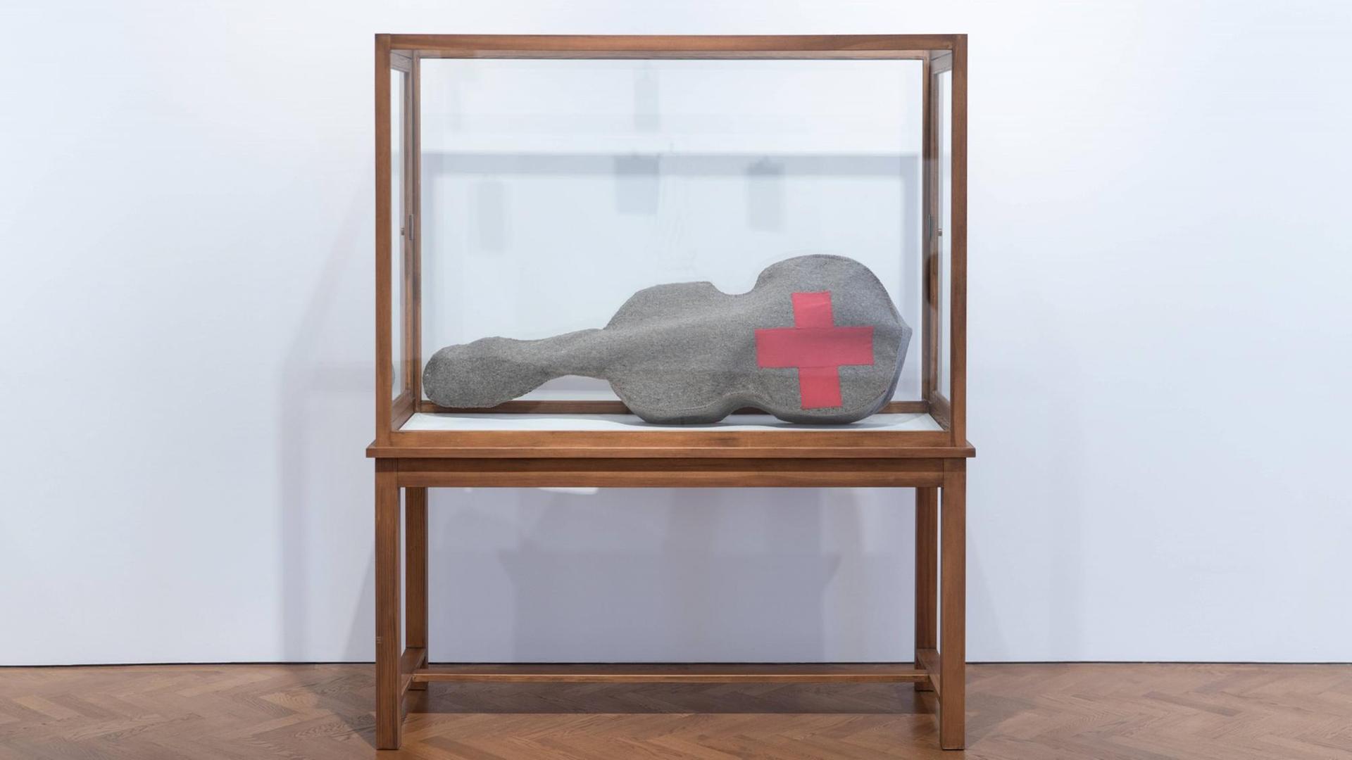 Beuys Arbeit 'Infiltration - Homogen für Cello' besteht aus einer gefilzten Cello-Tasche mit einem roten Kreuz. Hier zu sehen in einer Glasvitrine während der Ausstellung "The Stag Monuments" in der Galerie Thaddaeus Ropac in London, kuratiert von Norman Rosenthal. Beuys Arbeit 'Infiltration - Homogen für Cello' besteht aus einer gefilzten Cello-Tasche mit einem roten Kreuz. Hier zu sehen in einer Glasvitrine während der Ausstellung "The Stag Monuments" in der Galerie Thaddaeus Ropac in London, kuratiert von Norman Rosenthal.