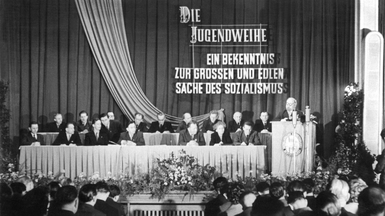 Aus Anlass des Bezirkstreffens mit Teilnehmern an der Jugendweihe in Gera spricht der 1. Sekretär des ZK der SED Walter Ulbricht am 2. Februar 1958 im Konzertsaal des Stadttheaters zu über 1000 Jugendlichen. Seit 1954 gehört die Jugendweihe, quasi als Ersatz zu Konfirmation oder Kommunion, zu einer gesellschaftlichen Einrichtung in der DDR. Jugendliche werden nach dem 8. Schuljahr feierlich in die Reihen der Erwachsenen aufgenommen und bekennen sich in einem Gelöbnis zu ihrem Staat. Aus Anlass des Bezirkstreffens mit Teilnehmern an der Jugendweihe in Gera spricht der 1. Sekretär des ZK der SED Walter Ulbricht am 2. Februar 1958 im Konzertsaal des Stadttheaters zu über 1000 Jugendlichen. Seit 1954 gehört die Jugendweihe, quasi als Ersatz zu Konfirmation oder Kommunion, zu einer gesellschaftlichen Einrichtung in der DDR. Jugendliche werden nach dem 8. Schuljahr feierlich in die Reihen der Erwachsenen aufgenommen und bekennen sich in einem Gelöbnis zu ihrem Staat.