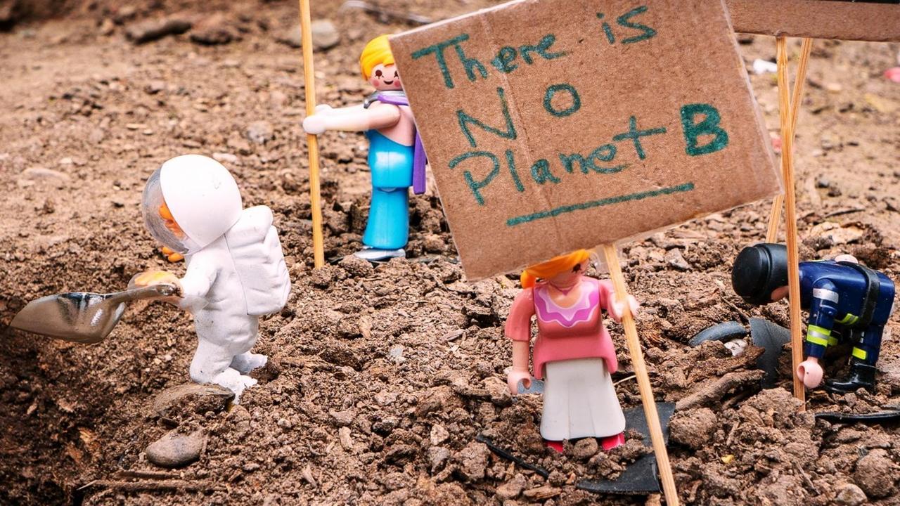 Playmobilfiguren mit einem Schild "There is no Planet B.". Playmobilfiguren mit einem Schild "There is no Planet B.".