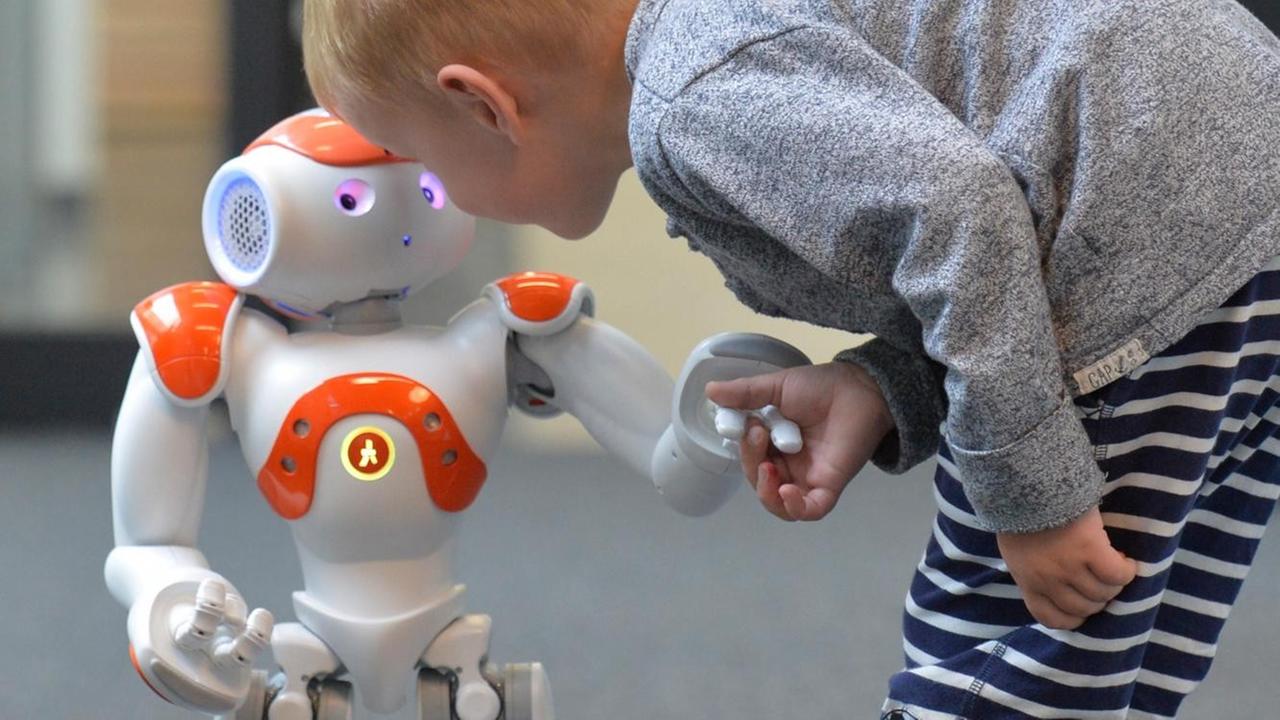 Der Roboter "Nao" mit einem Kind Der Roboter "Nao" mit einem Kind