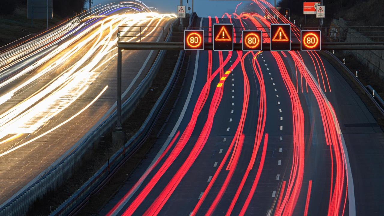 Die Scheinwerfer vorbeifahrender Fahrzeuge ziehen am Morgen auf der Autobahn 4 Lichtspuren Die Scheinwerfer vorbeifahrender Fahrzeuge ziehen am Morgen auf der Autobahn 4 Lichtspuren