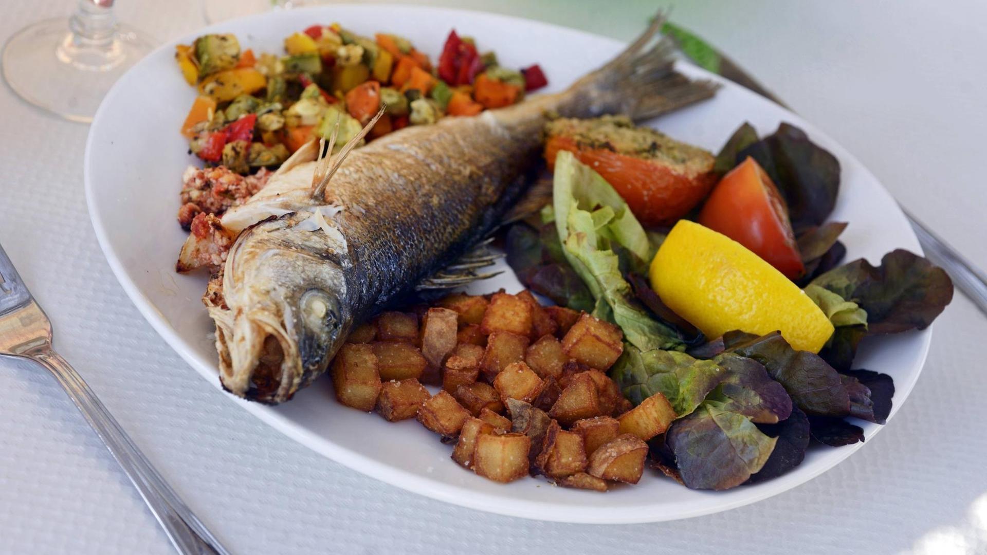 Ein Fischgericht auf Korsika. Fisch und Gemüse kennzeichnen die mediterrane Küche. Ein Fischgericht auf Korsika. Fisch und Gemüse kennzeichnen die mediterrane Küche.