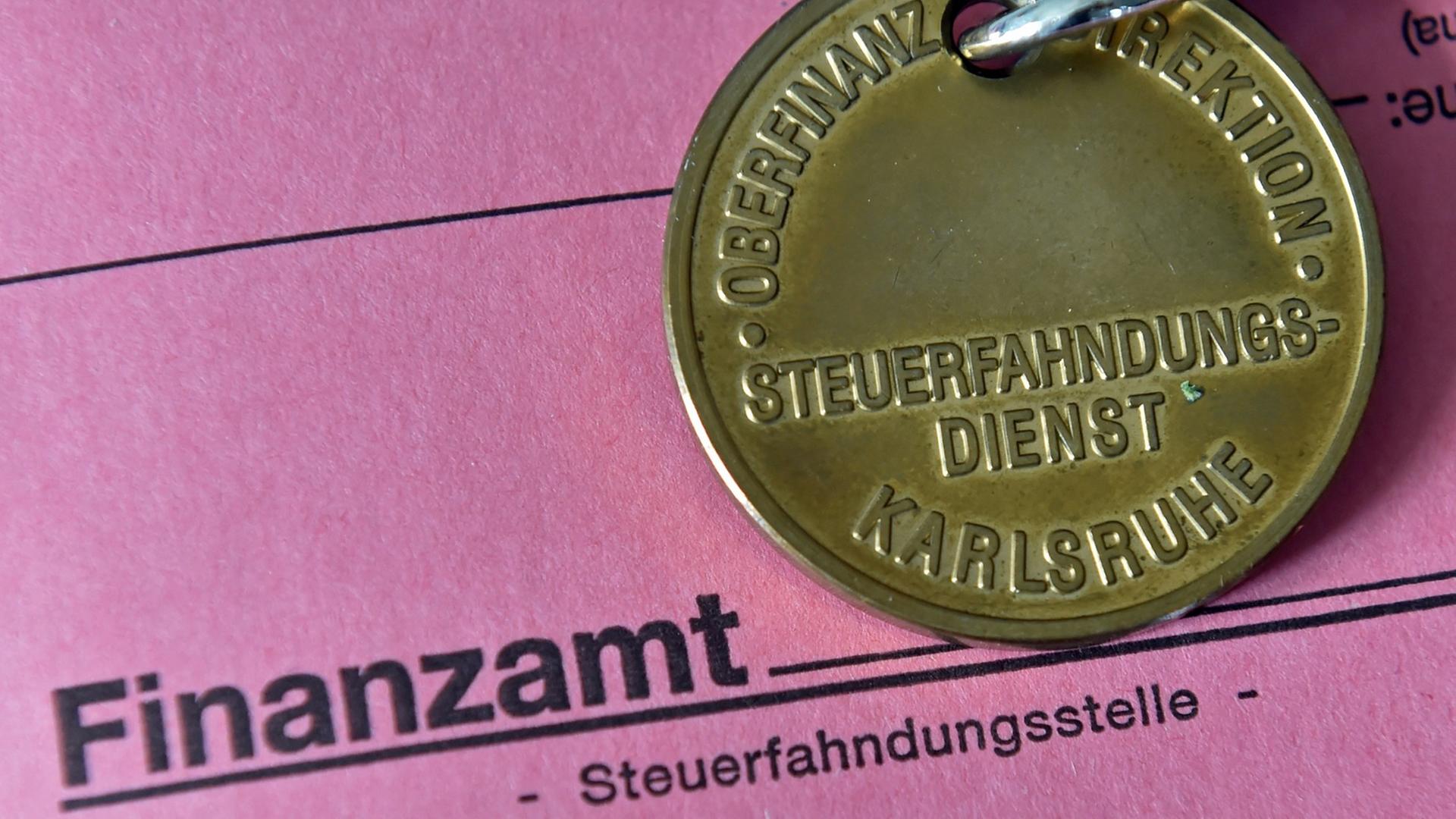 Dienstmarke eines Steuerfahnders auf einer Akte des Finanzamts Dienstmarke eines Steuerfahnders auf einer Akte des Finanzamts