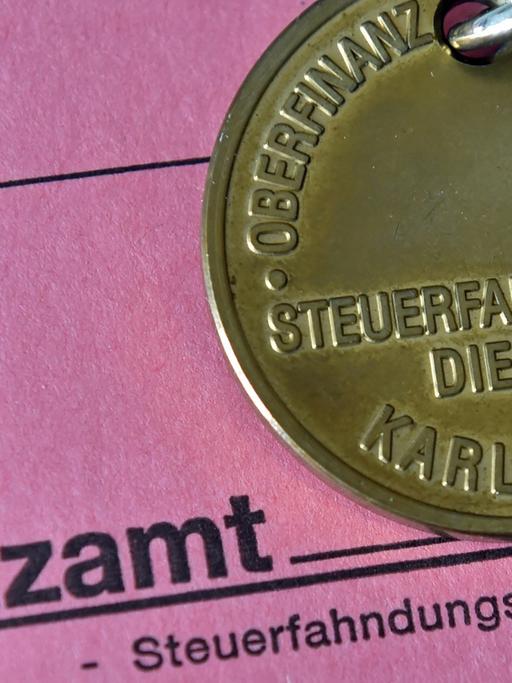 Dienstmarke eines Steuerfahnders auf einer Akte des Finanzamts