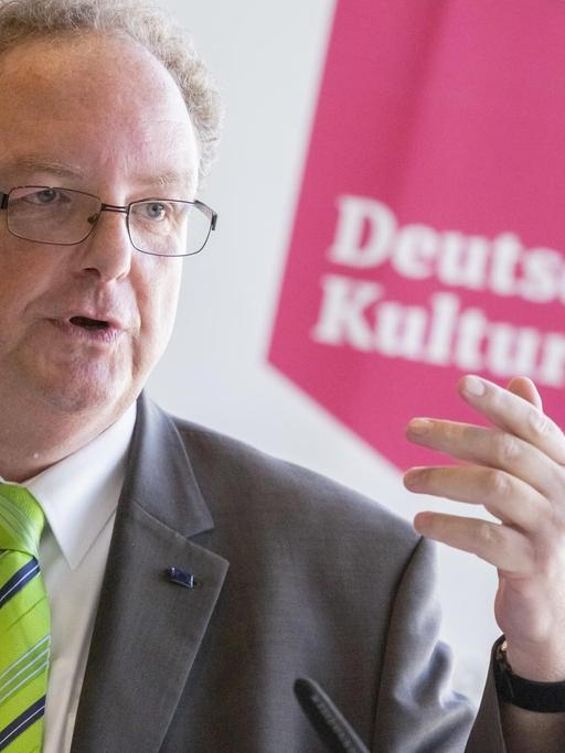 Olaf Zimmermann spricht auf einem Podium ins Mikrofon.