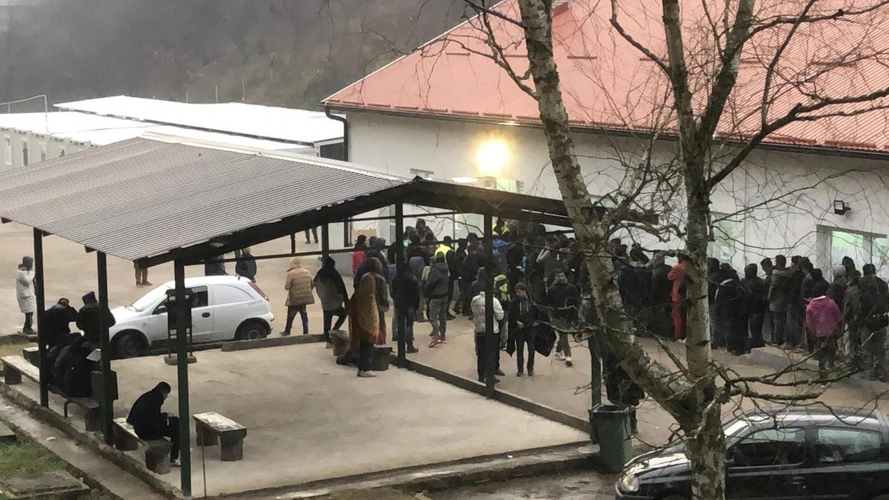 Menschen warten vor dem Gebäude des Flüchtlingslagers Menschen warten vor dem Gebäude des Flüchtlingslagers