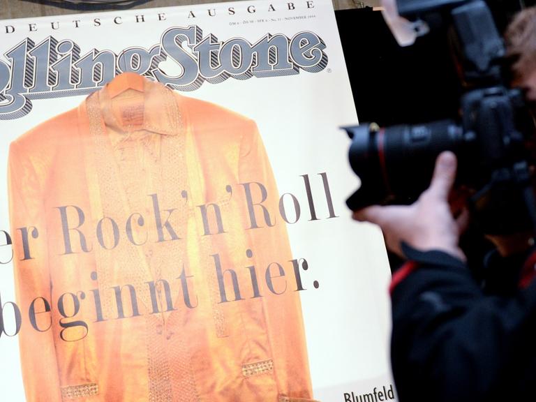 Ein Mann fotografiert zur der 20 Jahre Feier des Musik-Magazins "Rolling Stone" die erste Ausgabe.