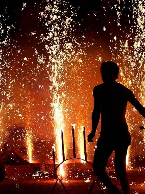 Die Silhouette einer Person ist vor einem Feuerwerk zu sehen, das in Erfurt anlässlich der Walpurgisnacht gezündet wird.