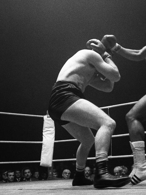 Charles Charly GRAF mit einem Gegner und Schiedsrichter im Ring. Schwarzweiß Aufnahme.