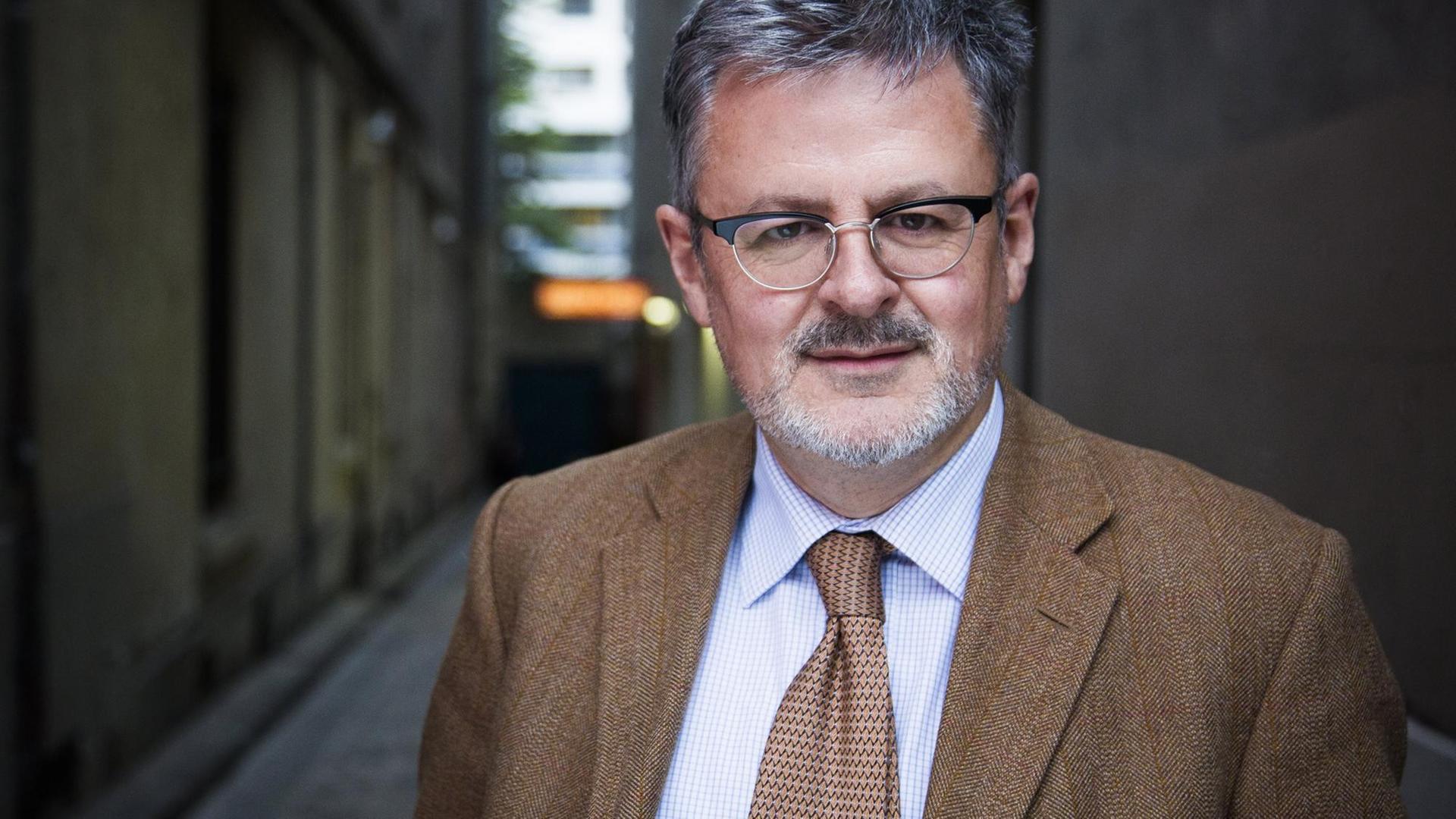 Christopher Clark steht in einer Gasse die im Hintergrund unscharf zu sehen ist. Er schaut freundlich in die Kamera. Christopher Clark steht in einer Gasse die im Hintergrund unscharf zu sehen ist. Er schaut freundlich in die Kamera.