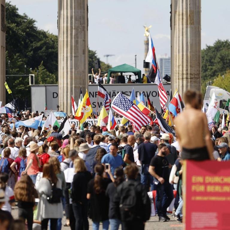 Demonstranten verschiedener Gruppierungen protestieren fahnenschwenkend in Berlin gegen die Maßnahmen zur Eindämmung der Corona-Pandemie