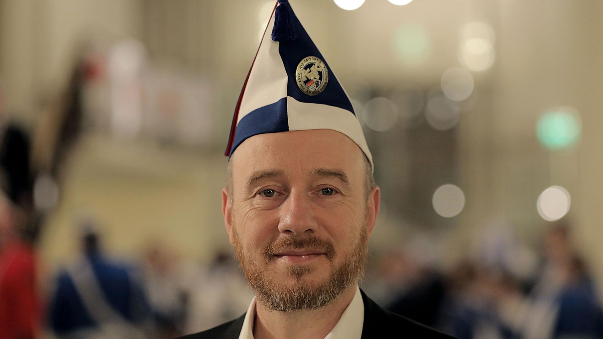 Aaron Knappstein, Präsident des jüdischen Karnevalsvereins "Kölsche Kippa Köpp", steht vor dem Besuch einer Sitzung im Foyer einer Halle in Köln. Aaron Knappstein, Präsident des jüdischen Karnevalsvereins "Kölsche Kippa Köpp", steht vor dem Besuch einer Sitzung im Foyer einer Halle in Köln.