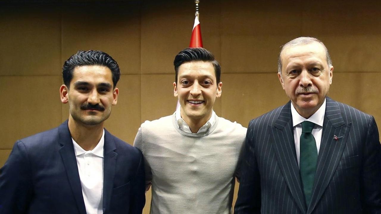 Recep Tayyip Erdogan (2.v.r.), Staatspräsident der Türkei, steht zusammen mit den Premier League Fußballspielern Ilkay Gündogan (l), Mesut Özil (2.v.l.) und Cenk Tosun (r).