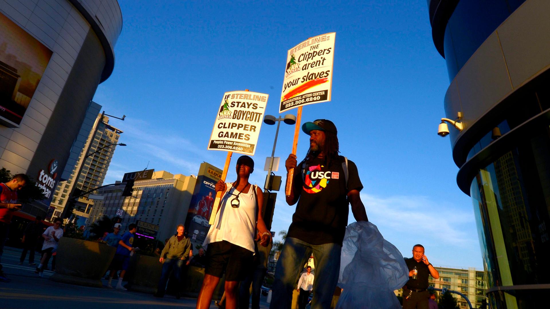 Demonstranten vor dem Staples Center in Los Angeles tragen Schilder, um gegen den Besitzer der LA Clippers, Donald Sterling, und dessen rassistische Aussagen zu protestieren. Demonstranten vor dem Staples Center in Los Angeles tragen Schilder, um gegen den Besitzer der LA Clippers, Donald Sterling, und dessen rassistische Aussagen zu protestieren.
