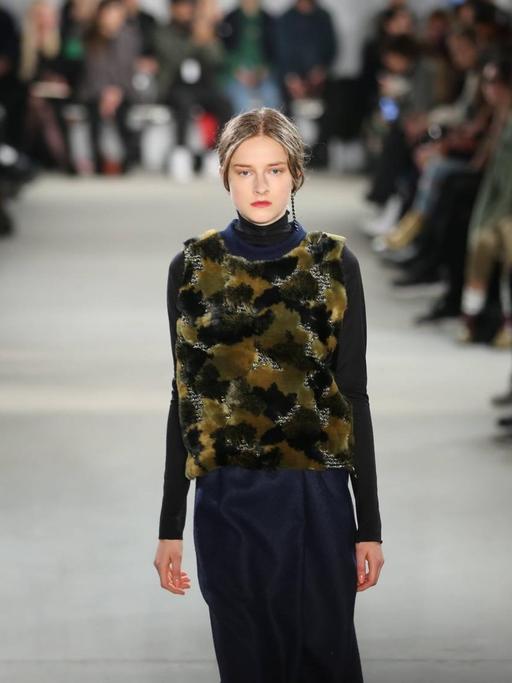 Vladimir Karaleev präsentiert seine neueste Kollektion auf der Berliner Fashion-Week 2017. Eine junge Frau trägt eine Abendrobe mit glitzerndem Tigerfellbesatz (Bild: imago stock&people / Simon Kuhlmey)