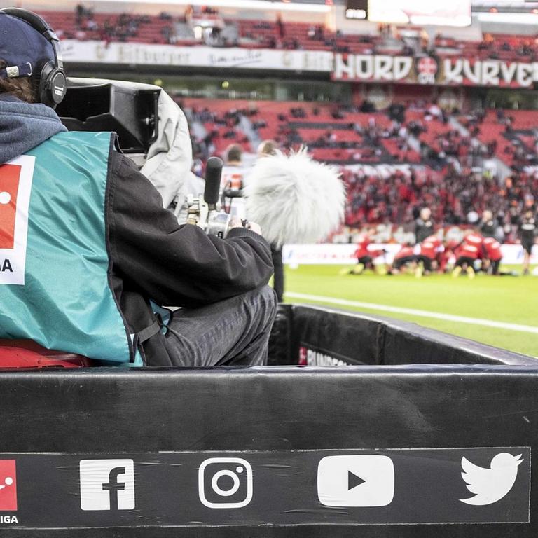 TV-Kameramann filmt am Spielfeldrand während der Live-Übertragung eines Spiels der Fußball-Bundesliga